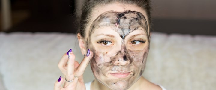 a woman with a face mask on holding her hand up to her face